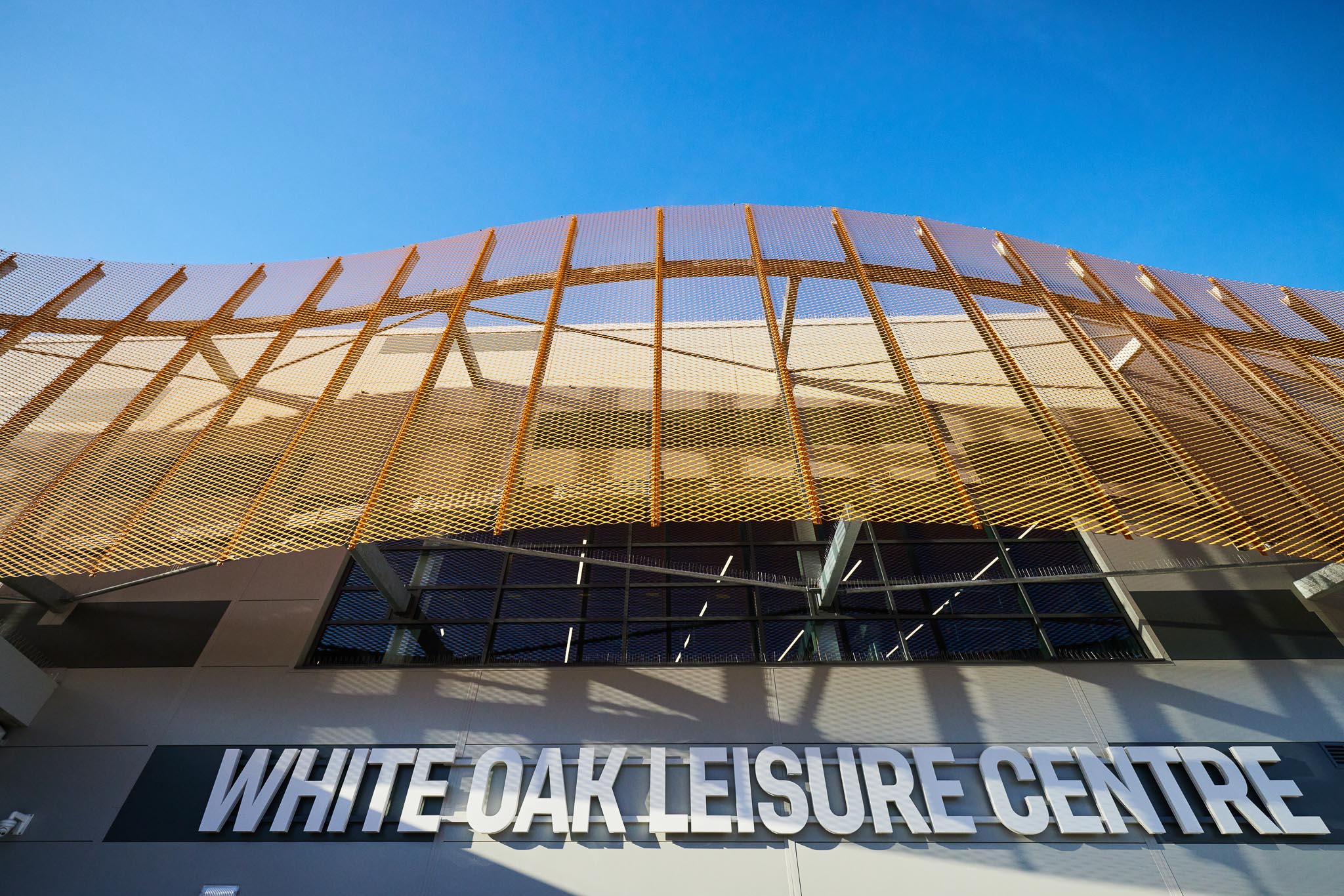 Expanded mesh architectural facade on white oak leisure centre